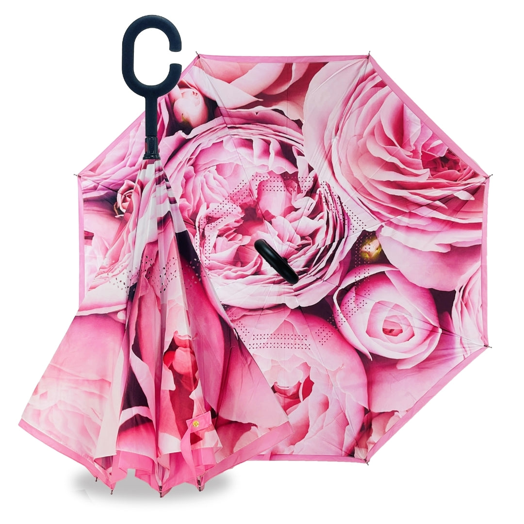 Reverse umbrella in Rose Bloom design, pink roses filling the open canopy, with a folded one standing in front and a black C-hook handle