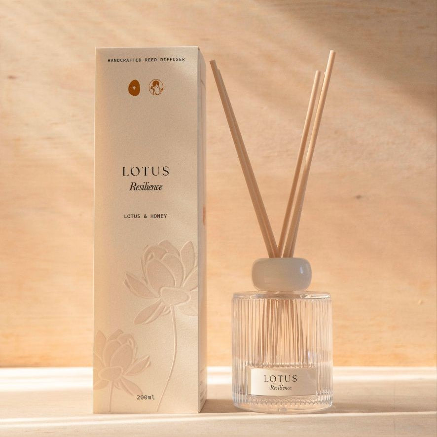 The Lotus reed diffuser, a ribbed glass bottle with natural reeds, beside its cream box.