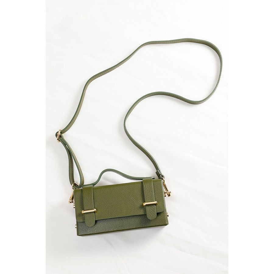 The khaki clutch laid flat with its long shoulder strap attached.