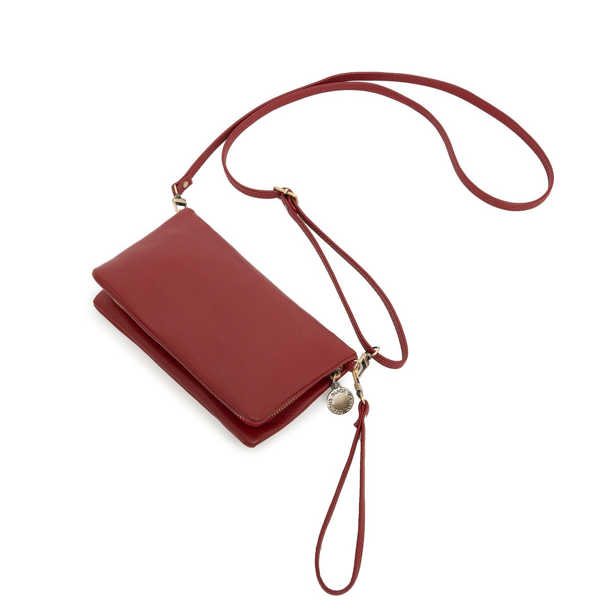 The red wallet at an angle with the long strap and wrist strap attached.