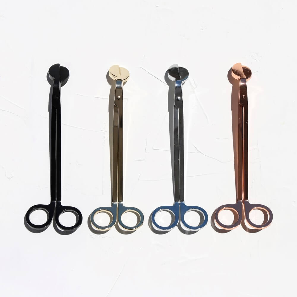 Four wick trimmers displayed upright in black, gunmetal, silver and rose gold
