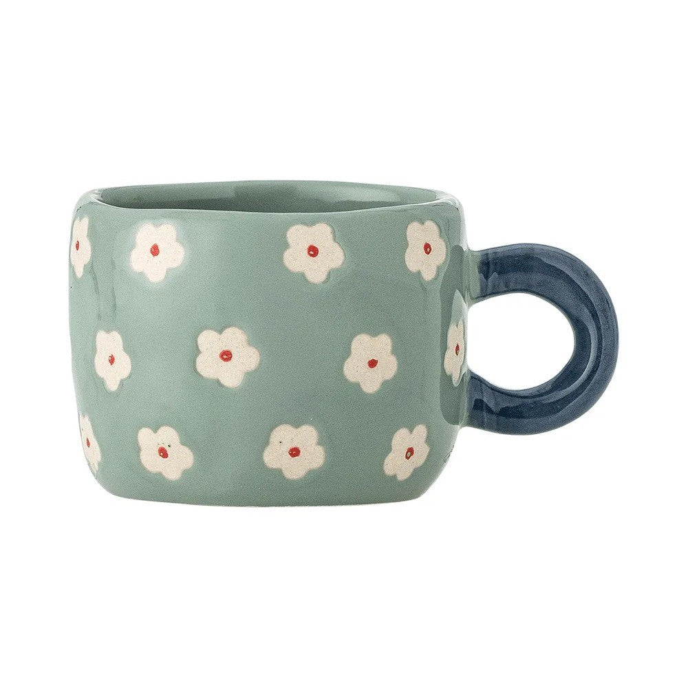 Sage green stoneware cup painted with white flowers with red centres, with a round navy handle