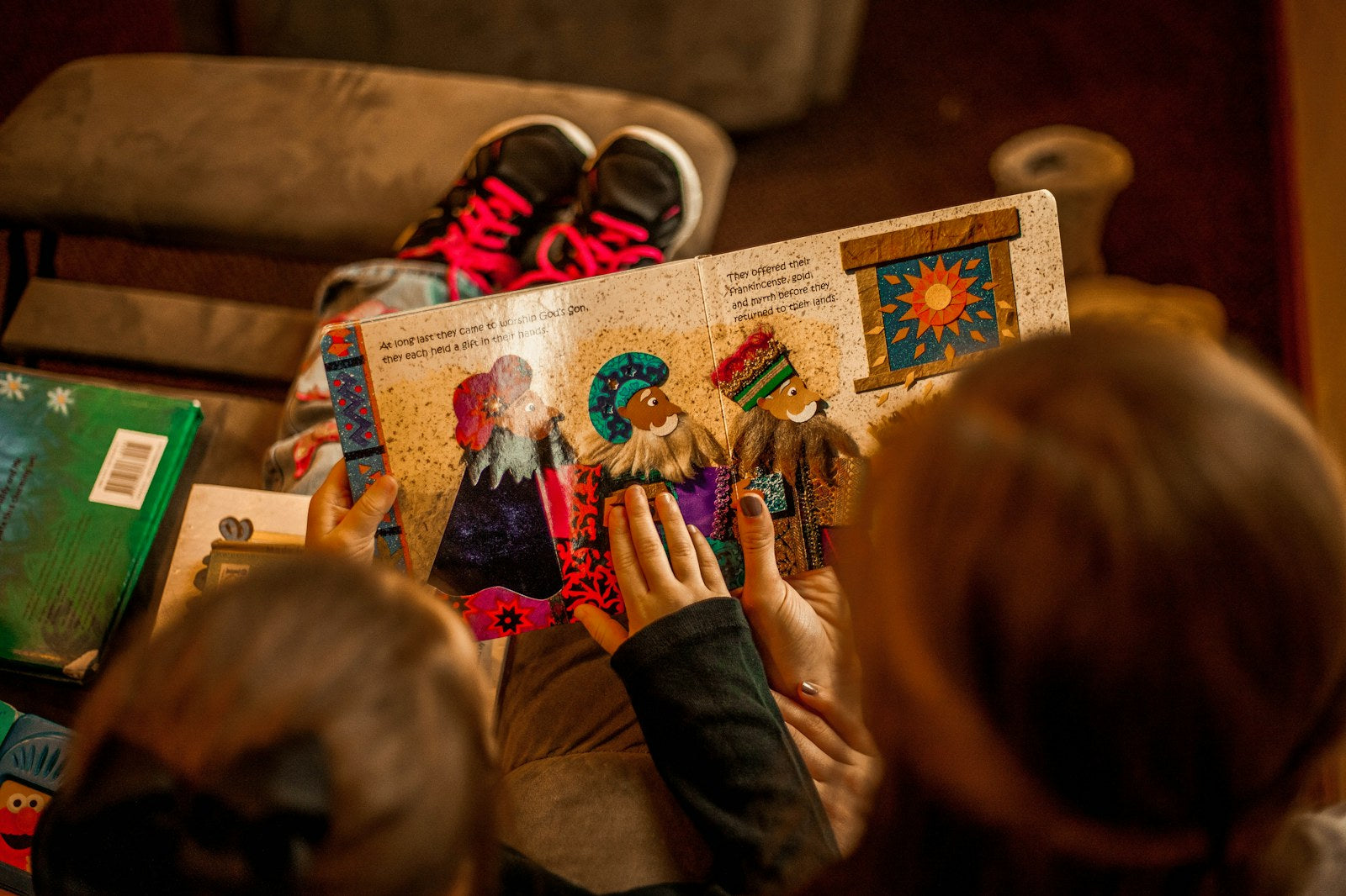Children reading an open picture book together in warm golden light