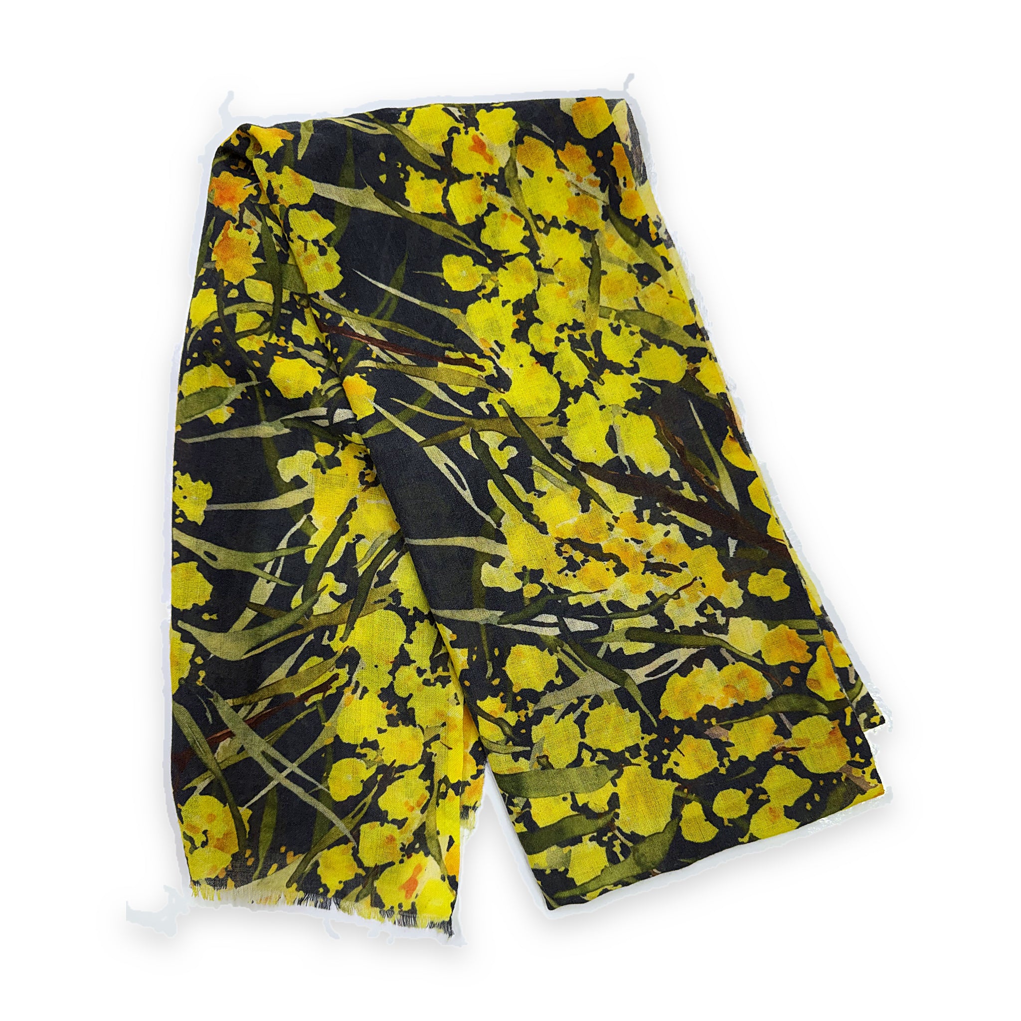 A merino wool scarf laid flat and folded in half, printed with yellow wattle blossom and olive-green foliage on a dark navy ground, with a fringed hem.