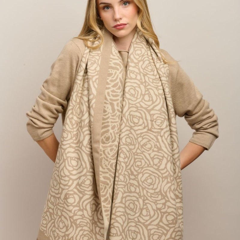 Model wearing the latte Wild Rose scarf draped long over a beige knit