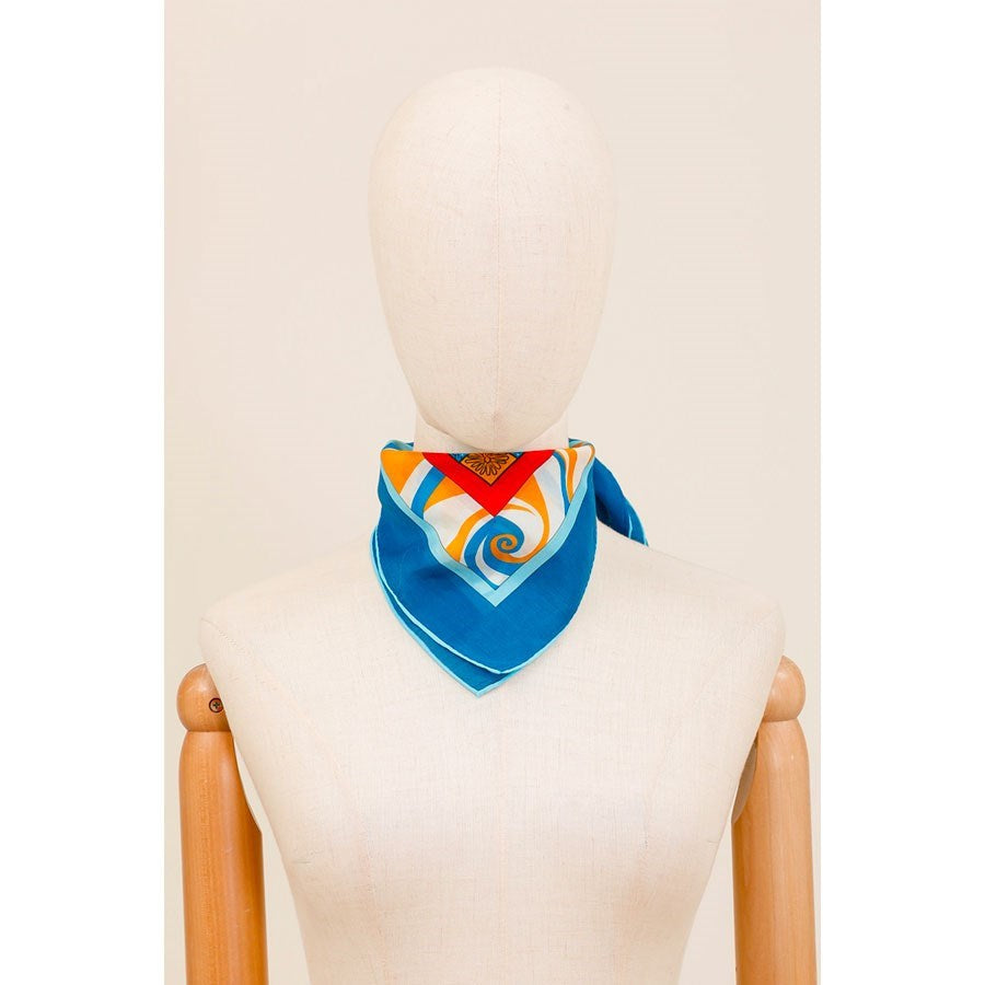 Astro Scorpio silk scarf on a mannequin, folded to show its blue border and orange swirl print