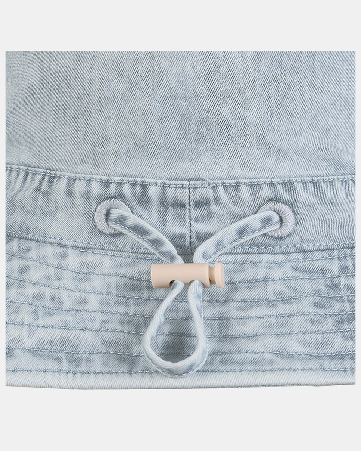 Close-up of the adjustable cord toggle at the back of the hat