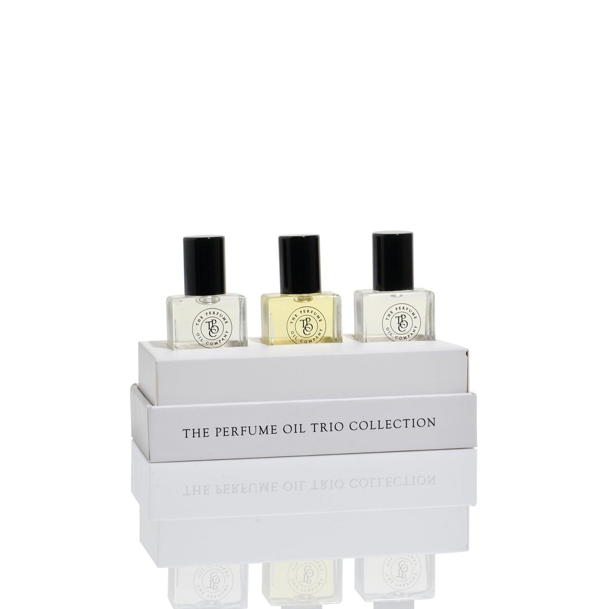 The three perfume oils standing in the open grey Perfume Oil Trio Collection box.
