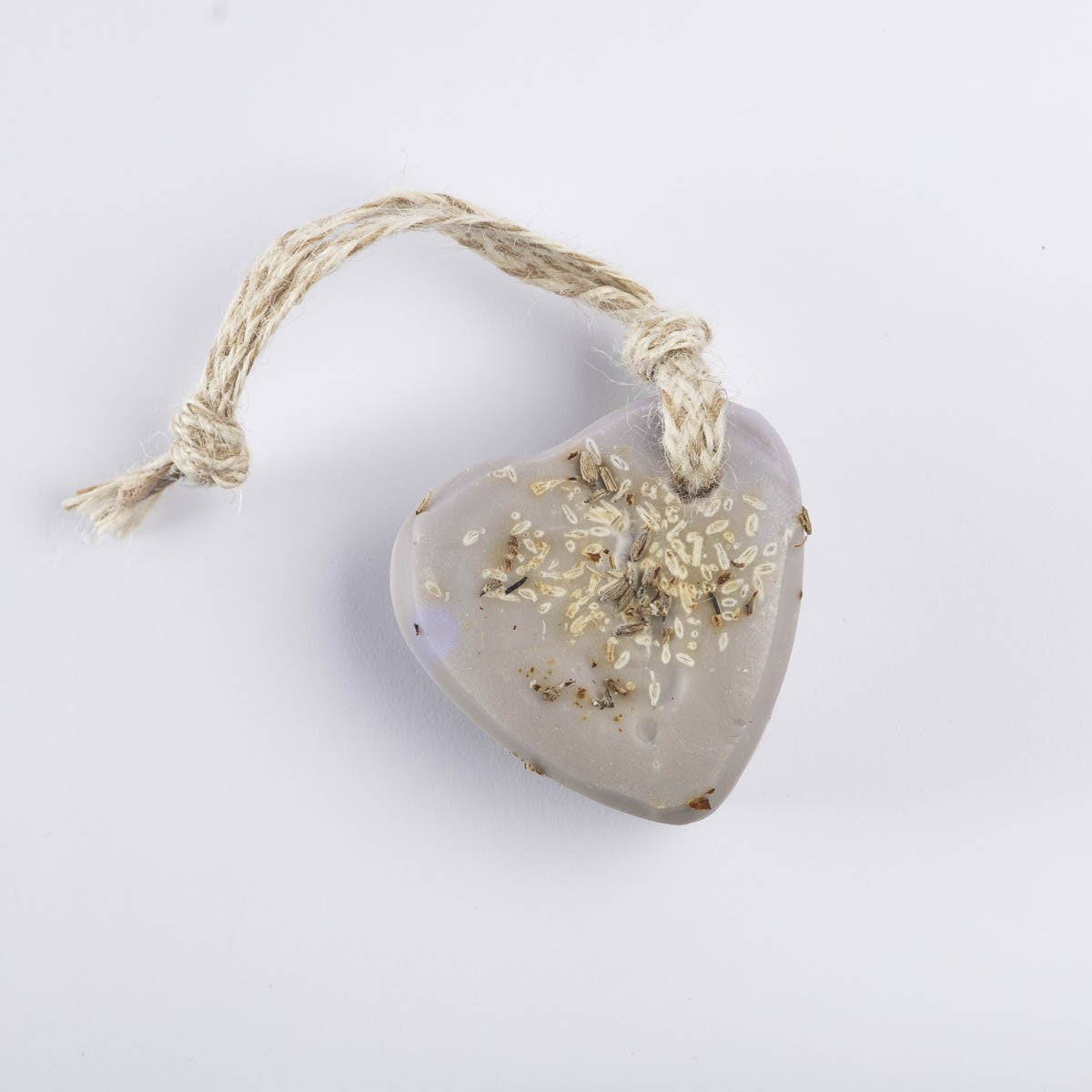 A pale lilac heart soap topped with lavender buds, with a jute loop