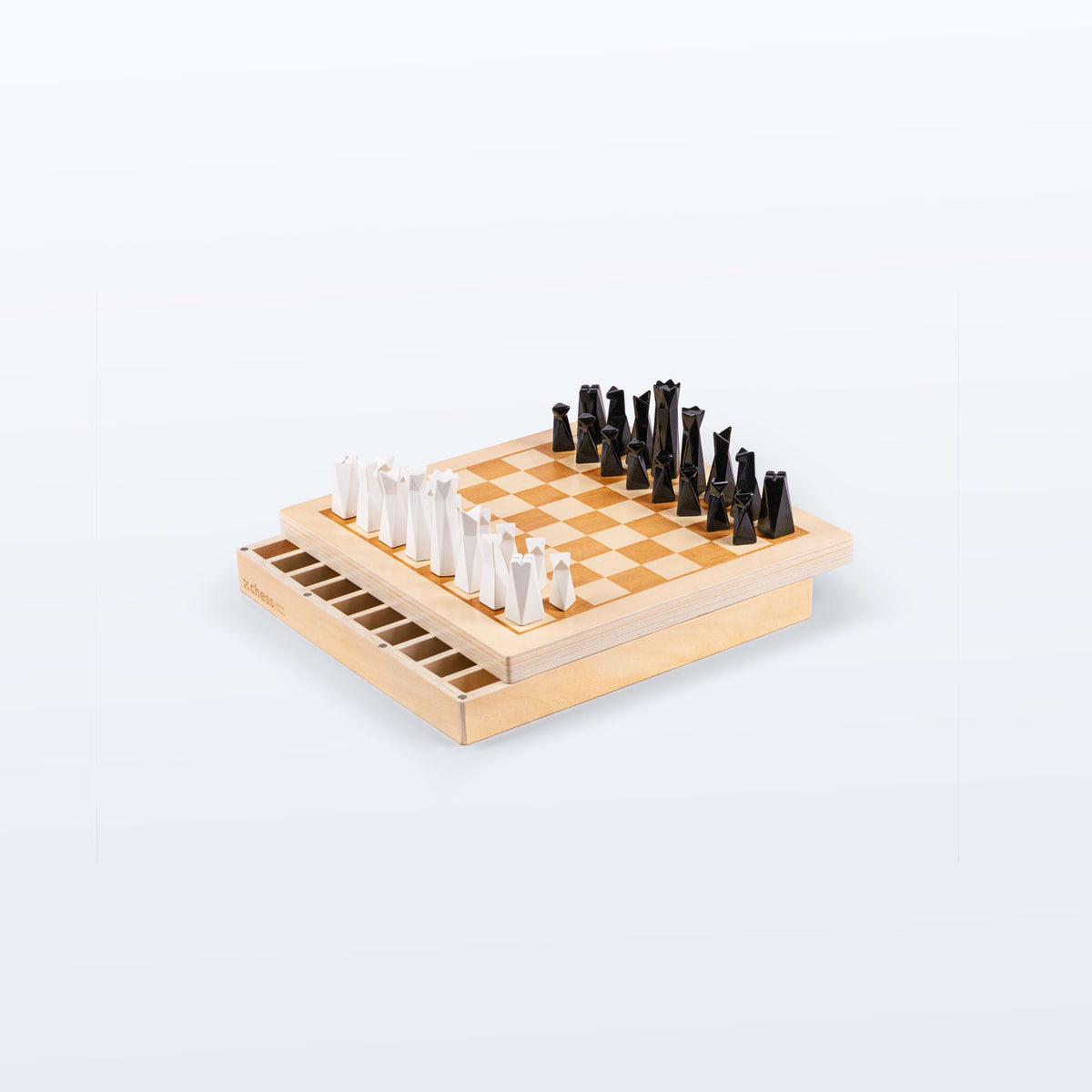 Planet Finska chess set with black and white geometric resin pieces on a linden plywood board, storage drawer open