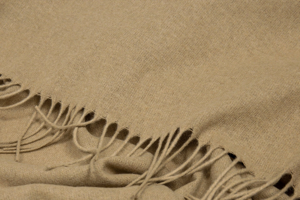 Close-up of the camel throw's fringe and soft flecked weave