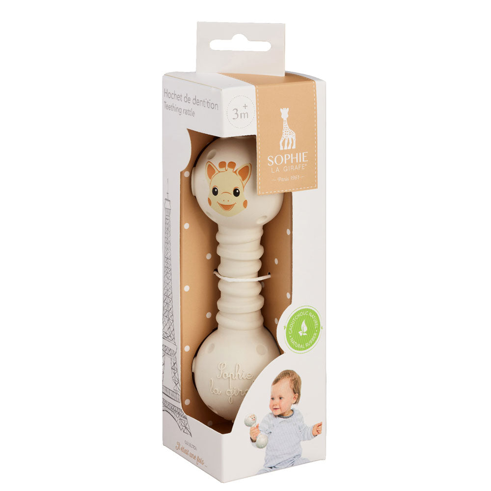 The cream teething rattle standing in its printed retail carton, which has a clear front panel and the Sophie la Girafe logo.