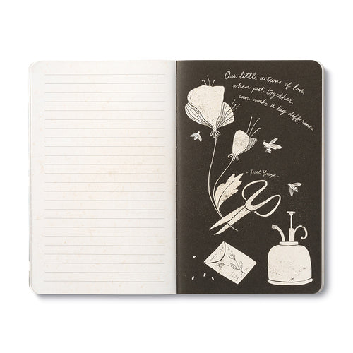 Open journal with lined pages beside a black page of white poppies, scissors, an envelope and an inkpot, with a line about little actions of love adding up