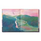 Open spread of a green valley with a winding path and a small figure walking it