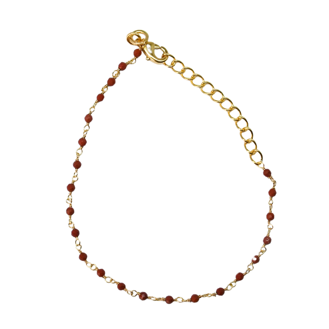 Fine gold bracelet with faceted deep red ruby beads and an extender chain