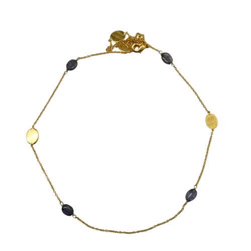 Fine gold chain necklace with dark blue-violet amethyst stones and brushed gold ovals, laid in a circle