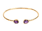 Euro Gold cuff bangle with two amethyst-purple gems on black background