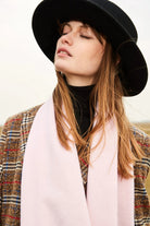 Model with chin nestled into the Dahlia pink merino scarf