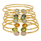 Stack of hammered Euro Gold cuff bangles with assorted oval gemstones