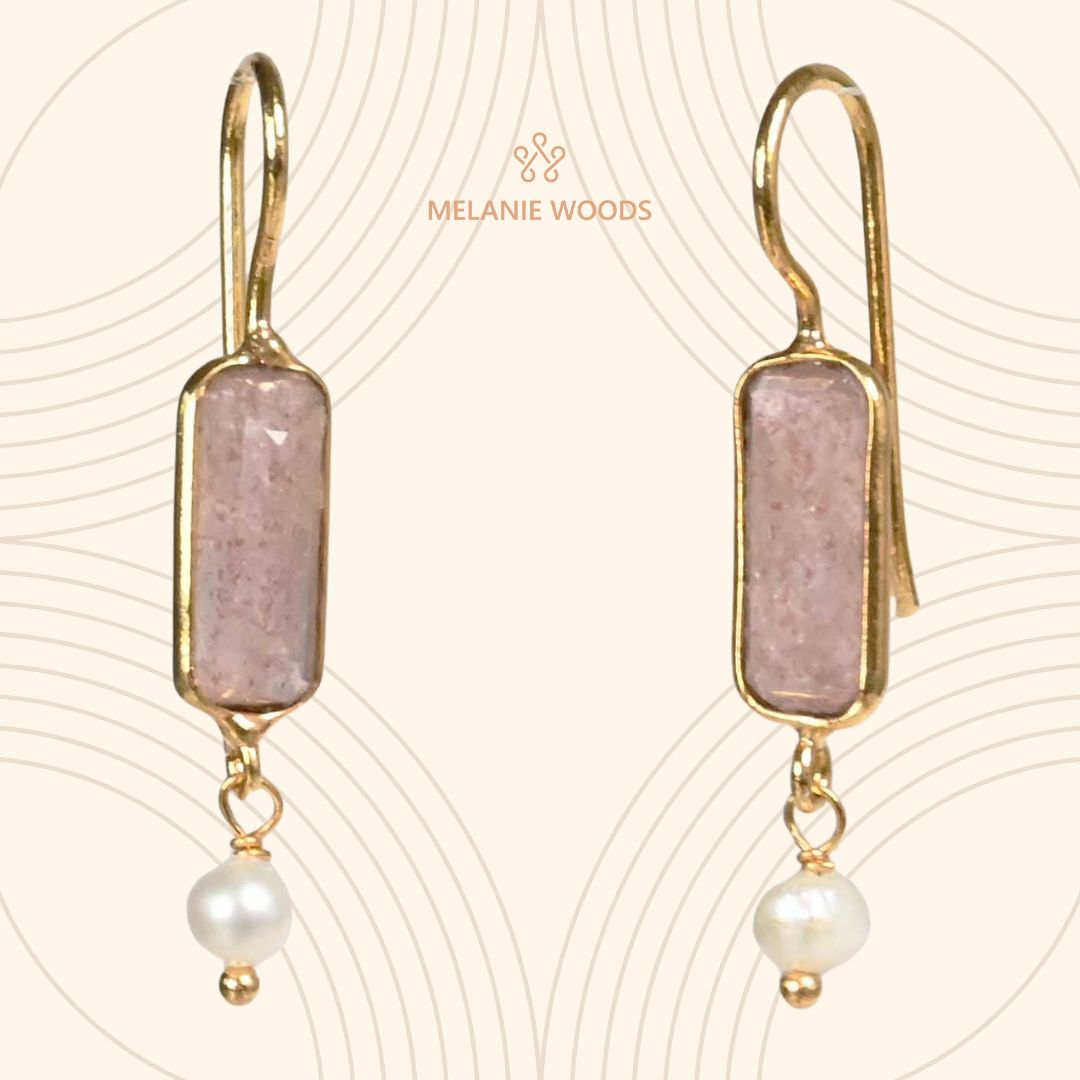 Euro Gold earrings with pale pink strawberry quartz bars and freshwater pearl drops, on patterned cream backdrop