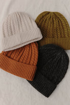 Four Palmer Beanies laid flat in cream, olive, rust and charcoal