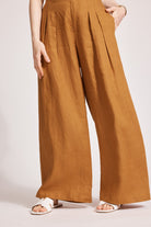 Close view of the wide caramel linen legs and white sandals