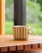 Archive mug in Olive on a slatted timber table by a window