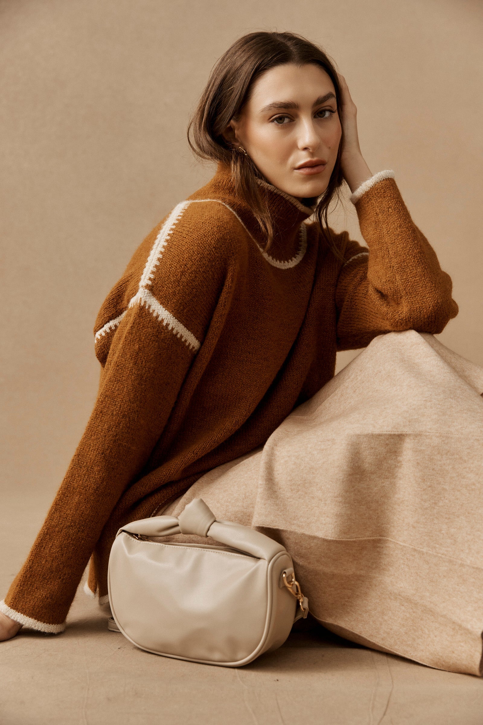 Model seated with the bisque Zala Bag beside her