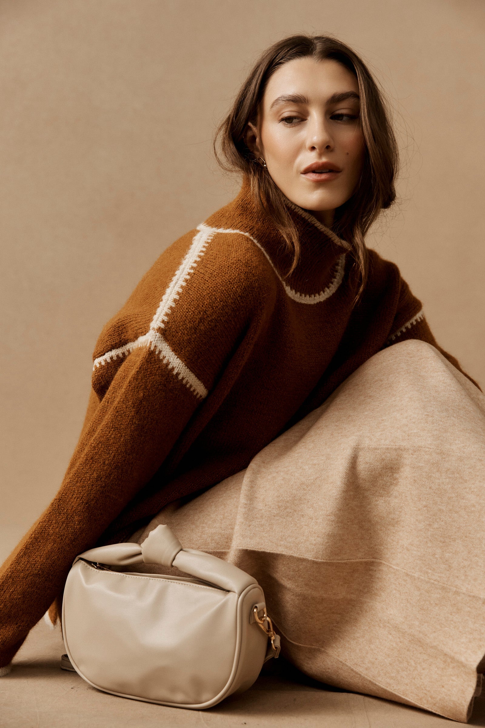 Model in a rust jumper with the bisque Zala Bag at her feet