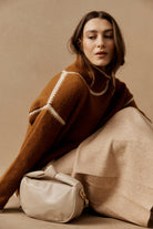 Model in a rust jumper with the bisque Zala Bag at her feet