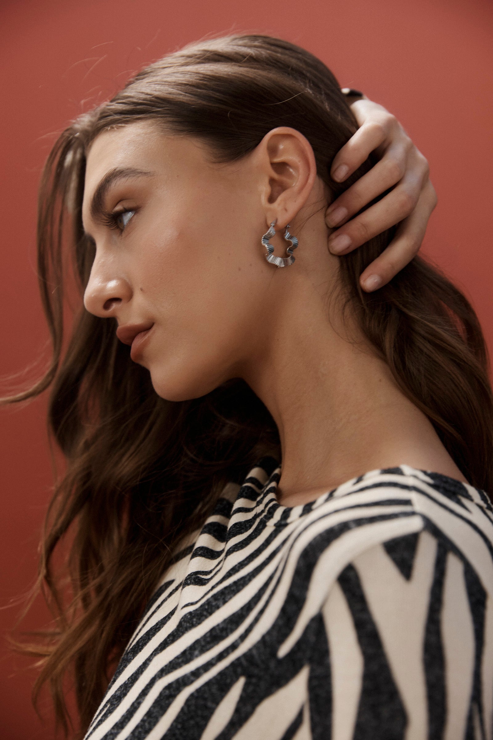 Model in zebra print wearing the silver Himba Scallop Hoop