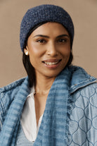 Smiling model in the denim marled beanie and blue jacket