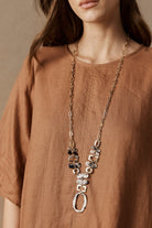 Model in a rust linen top wearing the long Nomad Chain