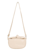 Zala Bag in Bisque hanging by its long crossbody strap