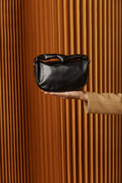 Black Zala Bag held aloft in front of timber battens