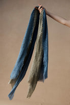 Hand holding Bodhi Scarves in lake and sage colourways