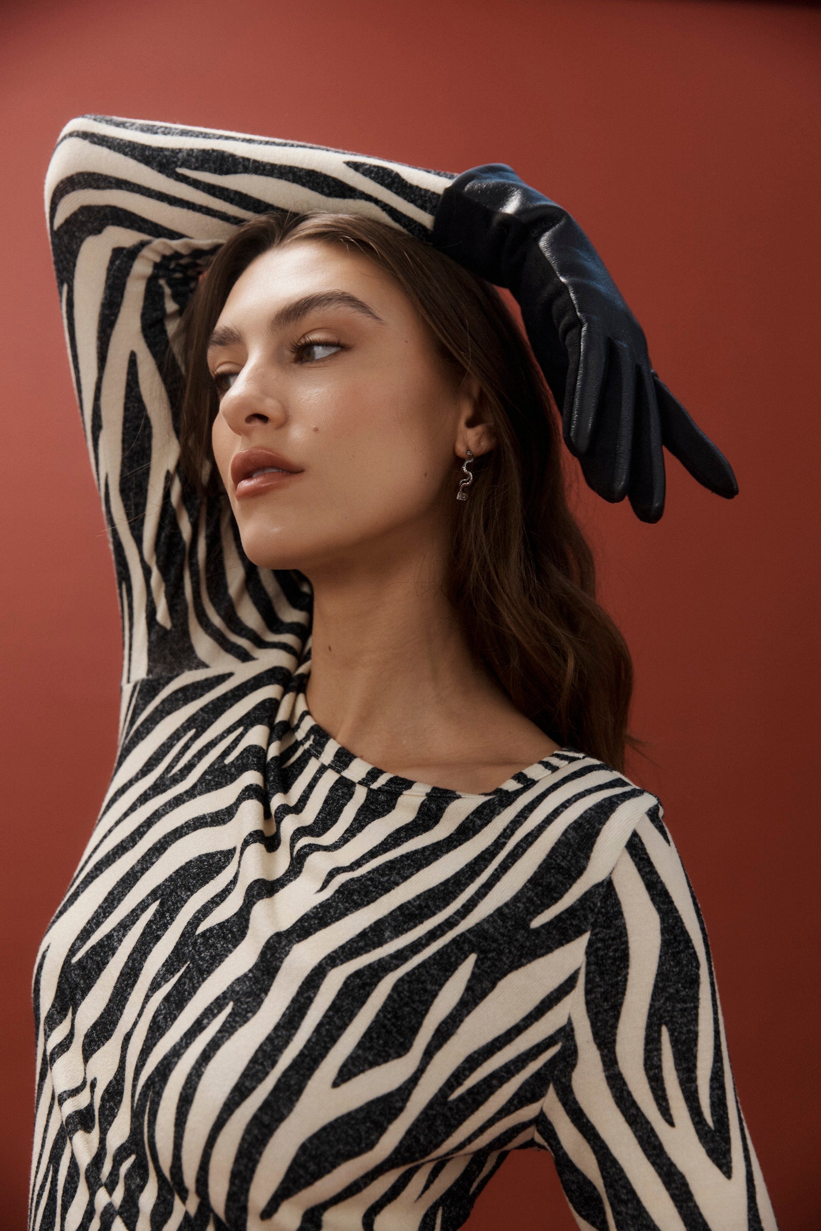 Model posing with arm raised wearing the silver scallop hoops
