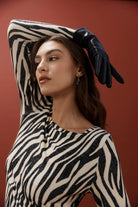 Model posing with arm raised wearing the silver scallop hoops