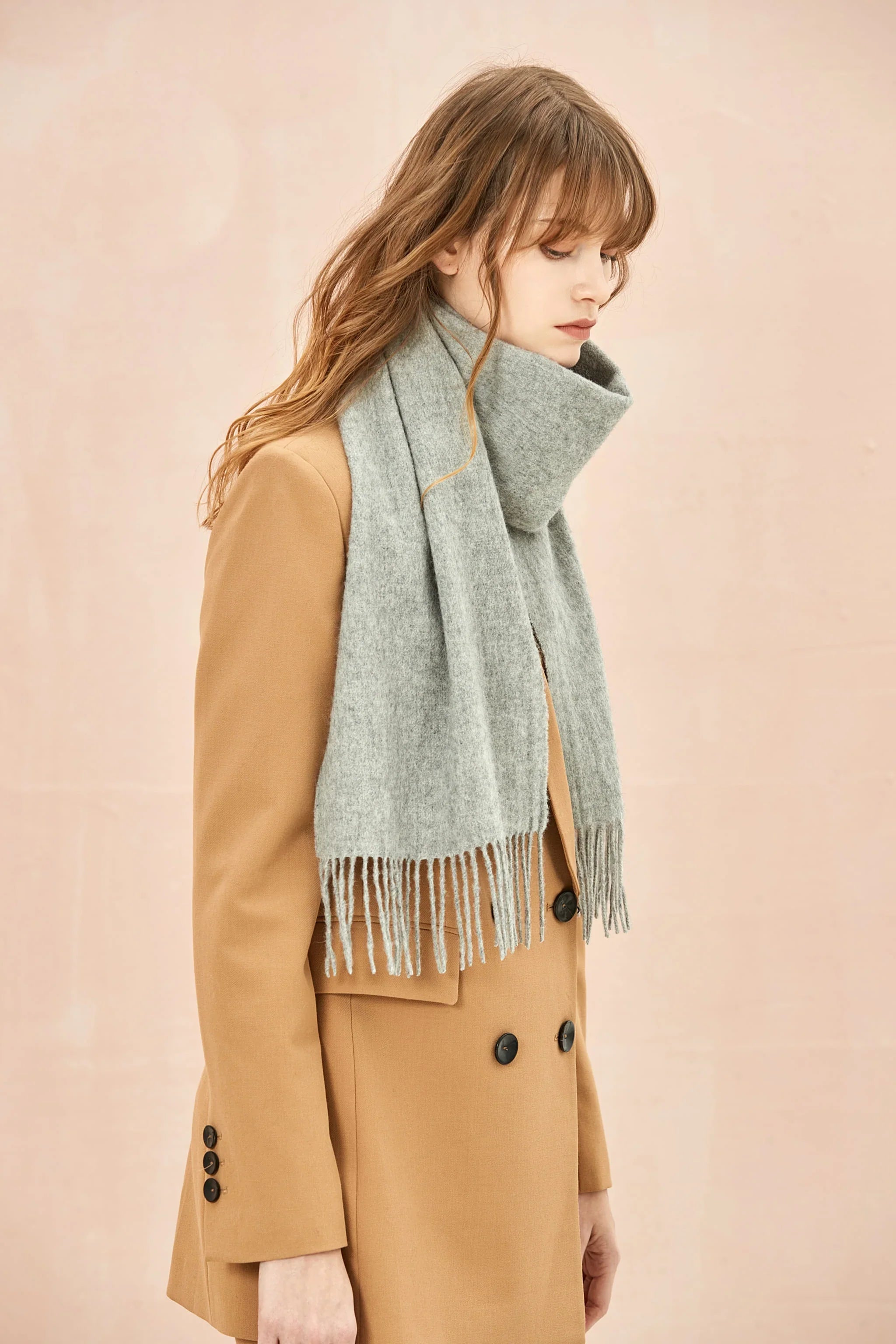 Quartz light grey scarf draped over a camel blazer, side view