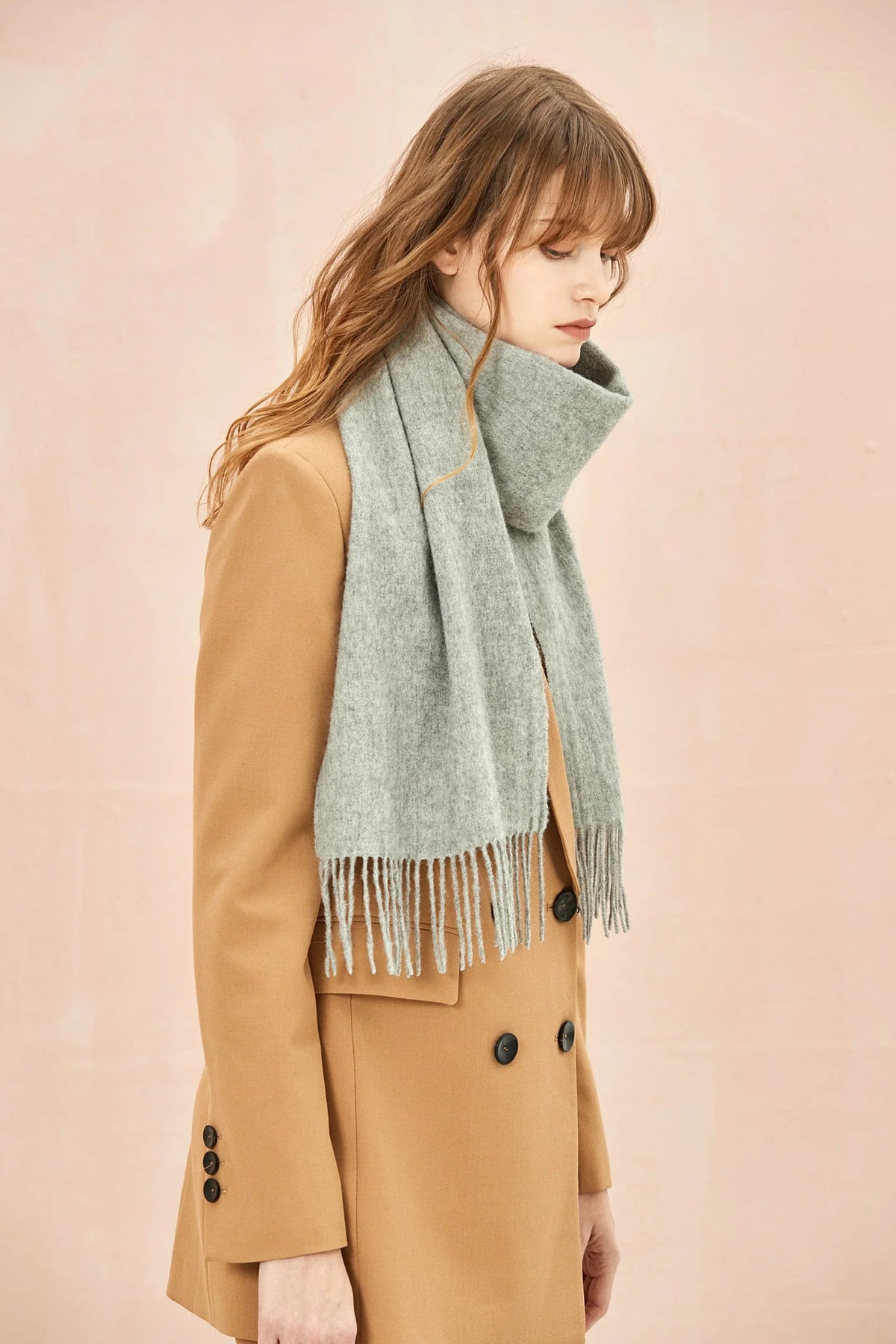 Quartz light grey scarf draped over a camel blazer, side view