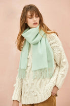 Pistachio mint scarf draped long over a cream jumper