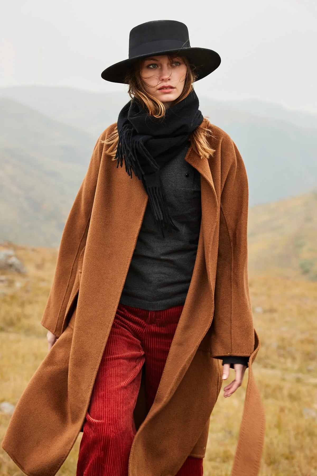 Outdoor look in a black hat with the Ebony scarf and rust trousers