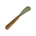 Pâté knife with a sage green blade, a steel collar and a plaited wicker handle with a timber end cap, on white