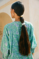 Back view of a woman with a long dark ponytail held by the silver cuff hair tie