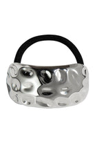 Curved hammered silver-tone metal cuff on a black elastic hair tie