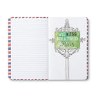 Open journal with a breakout page of a Parisian sign reading: will kiss for a trip to Paris