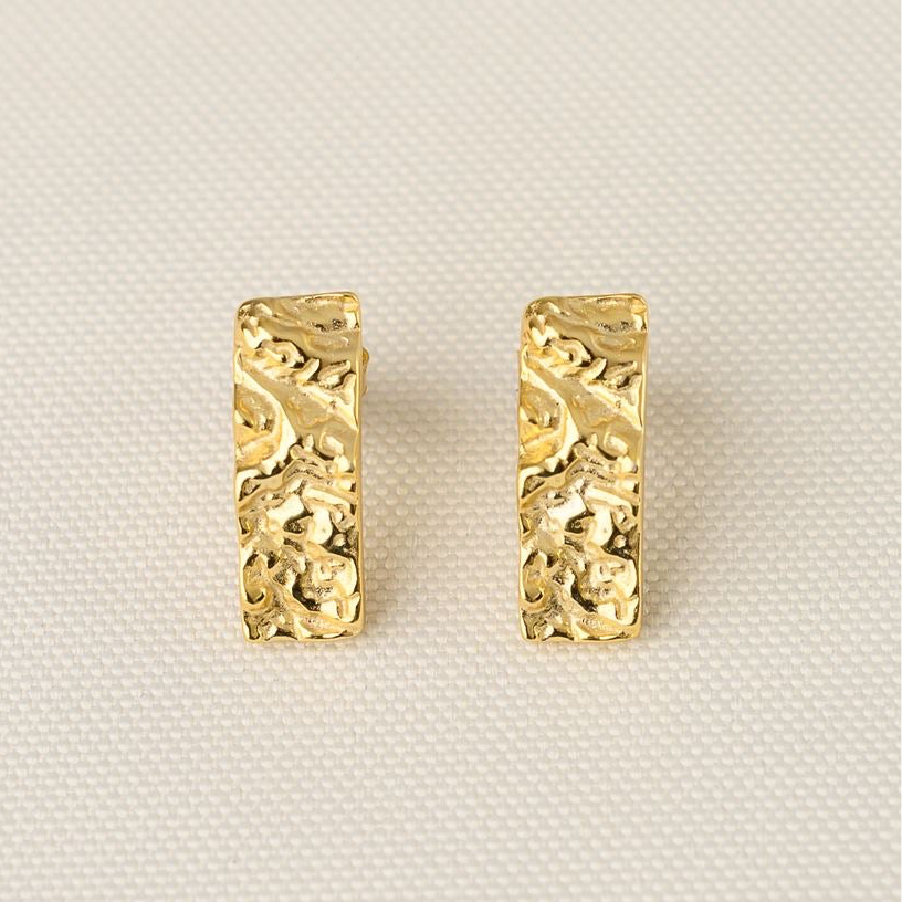 Close view of the pair of Bella gold earrings showing the crushed-metal texture