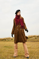 Model walking in grassland with the Rhubarb scarf and camel pants