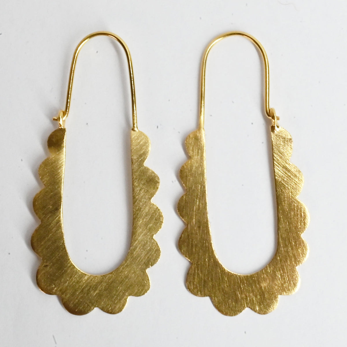 Brushed gold long U-shaped hoop earrings with a scalloped edge and a fine wire top