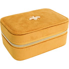 Angled view of the closed mustard velvet jewellery case showing its zip-around design